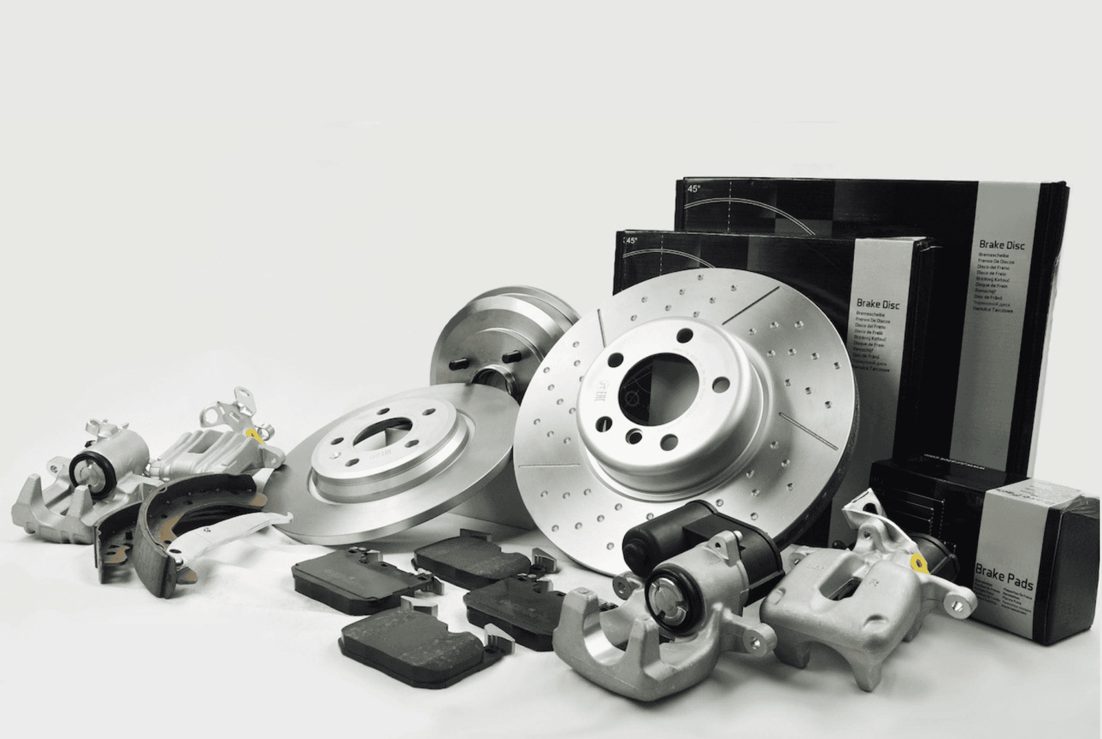 Close-up of a car brake disc and caliper with suspension springs in the background, representing automotive braking and suspension parts